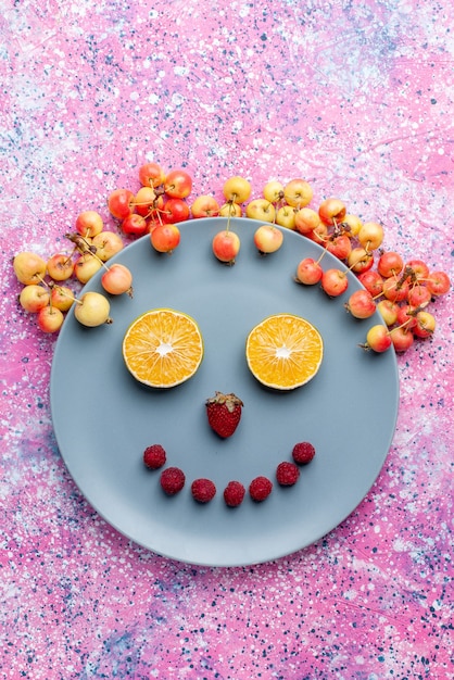 Бесплатное фото Верхний далекий вид улыбка из фруктов внутри тарелки на ярко-розовом столе фрукты свежие спелые спелые цвета