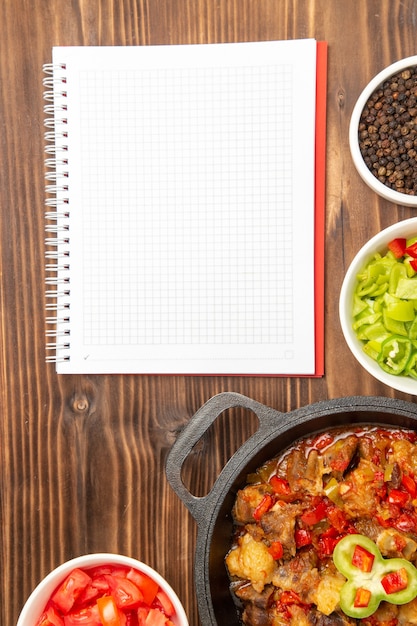 Top distant view vegetable meal with sliced bell-pepper salad on brown surface