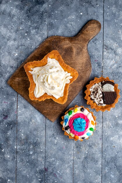 Top distant view yummy creamy cakes star shaped with cookie cakes on light, cake biscuit cream sweet tea