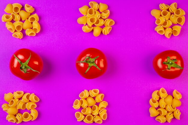 top  ditalini raw pasta with fresh tomatoes on purple