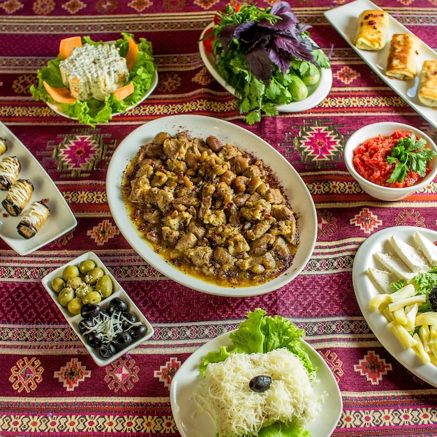 top fried meat with chestnuts served with various food on colorful rug