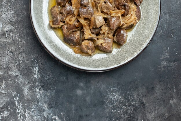 Top half view baked liver and onion on grey oval plate 