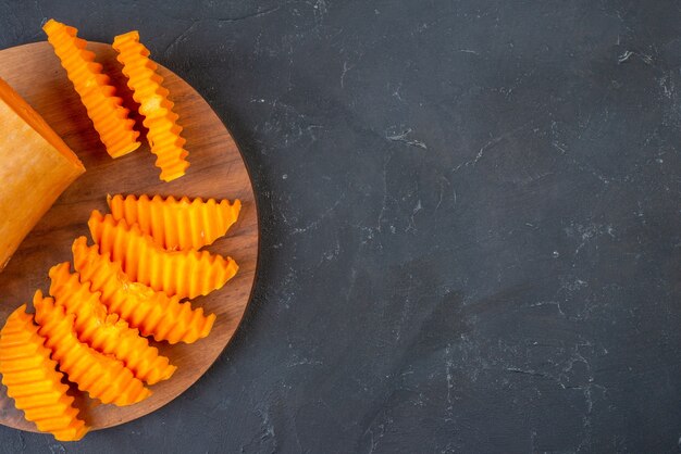 Top half view butternut squash slices on wood board on table