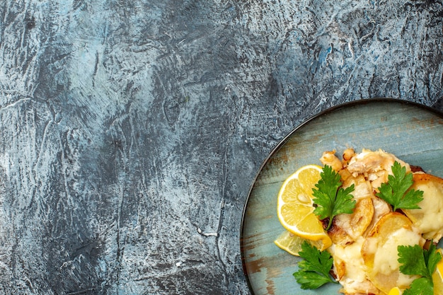 Pollo di mezza vista superiore con formaggio sul piatto sul tavolo grigio con posto di copia