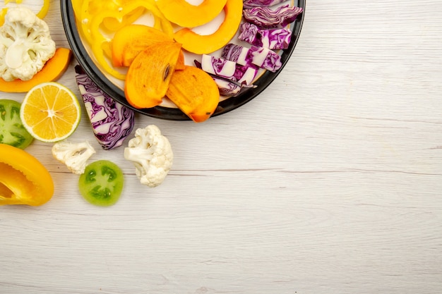 상위 절반보기 잘라 야채와 과일 호박 감 붉은 양배추 레몬 그린 토마토 복사 장소 테이블에 검은 접시에 스톡 사진