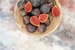 Free photo top half view fresh persimmons in wicker basket on nude background