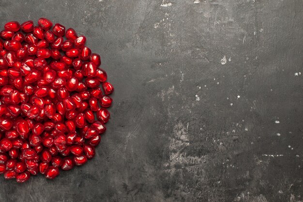 Top half view pomegranate seeds on dark background