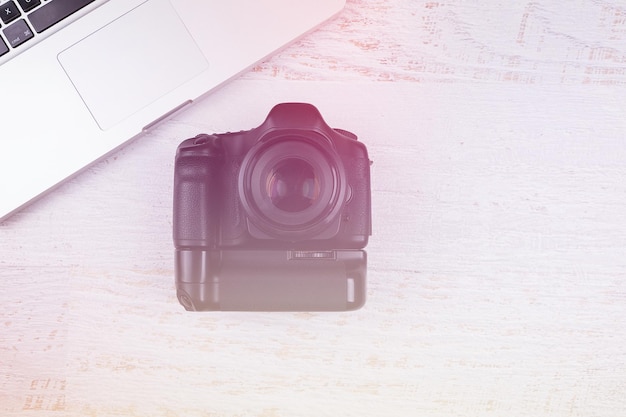 Free photo over top photo of camera and laptop on wooden background