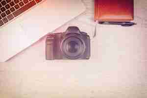 Free photo over top photo of dslr camera and laptop on wooden background