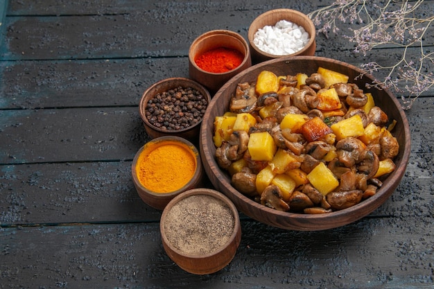 Free photo top side view plate and spices plate with potatoes and mushrooms and colorful spices around it