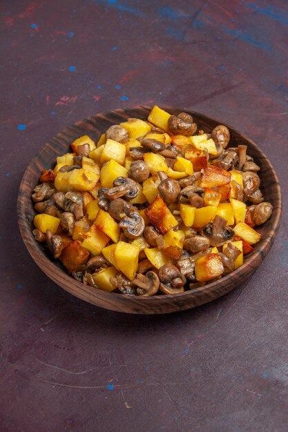 Top side view potatoes with mushrooms on the dark surface there is a brown bowl wih potatoes and mushrooms