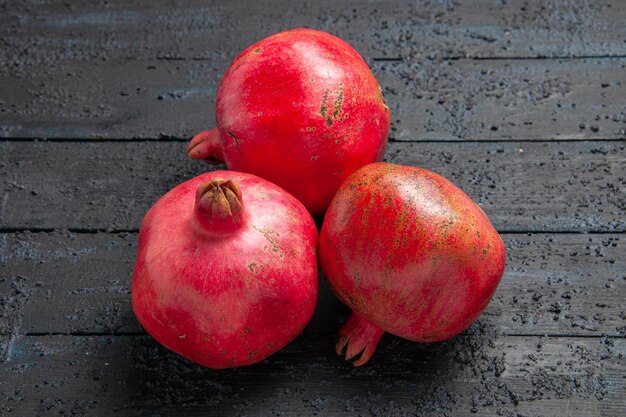 Top side view ripe pomegranates three ripe pomegranates on dark surface