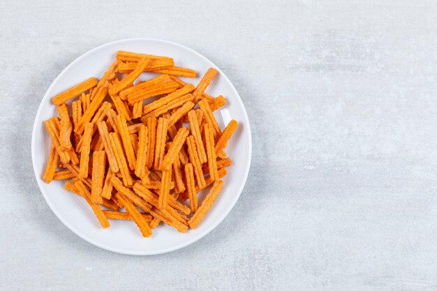 Top up view of fresh fries on white plate.