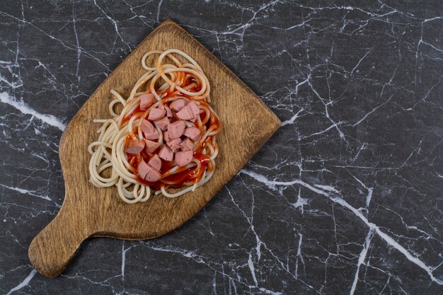Верхний вид домашних спагетти пасты и колбасы с соусом.