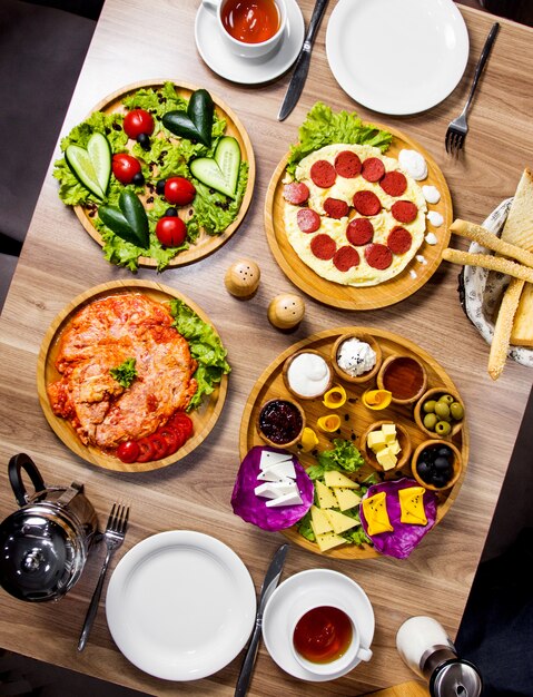 Top vertical view of breakfast setup with egg dishes side dish platter and vegetables platter