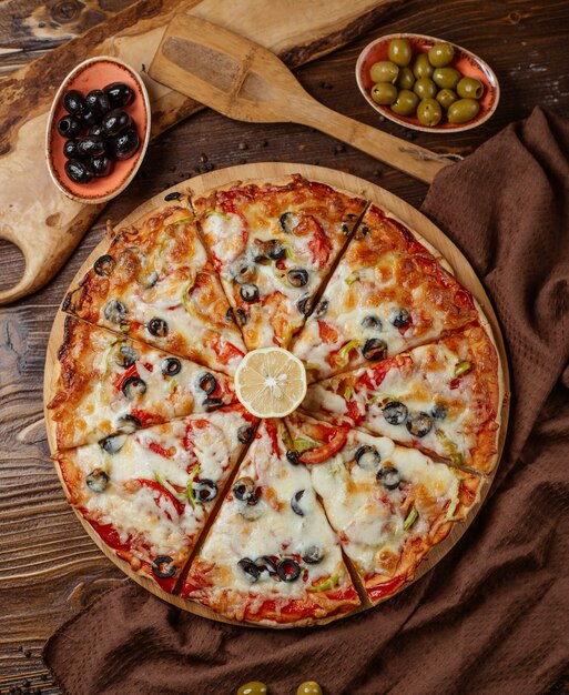top view of 8 pieces mixed pizza with olive, tomato, bell peppers