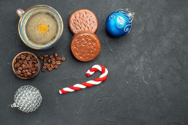 Бесплатное фото Вид сверху чашку кофе с семенами кофе и печенье рождественские детали на темном изолированном фоне