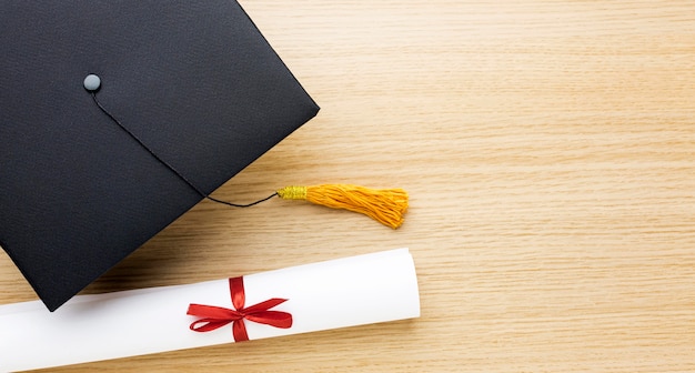 Foto gratuita vista dall'alto del cappello accademico con diploma e copia spazio