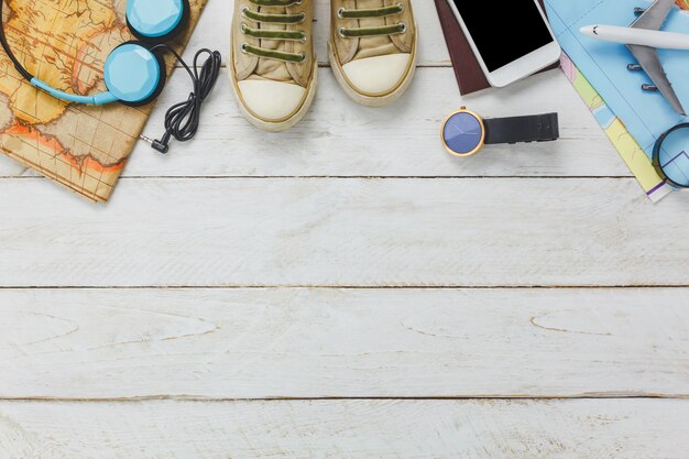 Вид сверху accessoires для путешествий concept.White мобильный телефон и наушники на деревянном фоне.