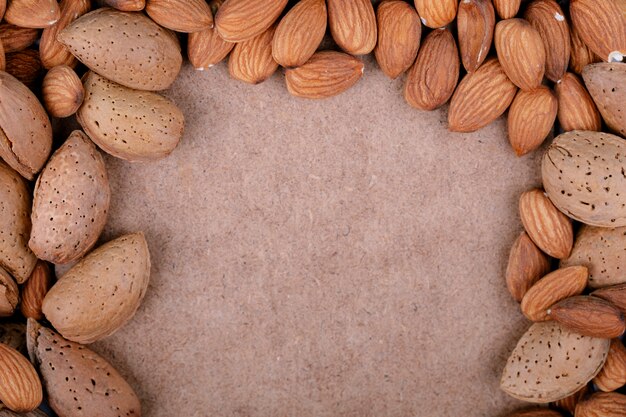 Top view of almond nuts on old paper texture background with copy space