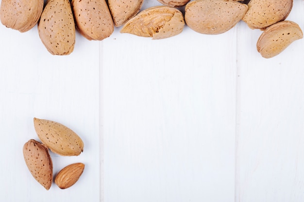 Top view of almond nuts in shell on white background with copy space