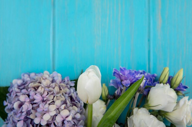 복사 공간이 파란색 배경에 잎 라일락 장미 튤립 같은 놀라운 화려한 꽃의 상위 뷰