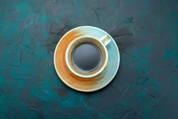 Top view of americano with shadow effect on saucer on dark blue,