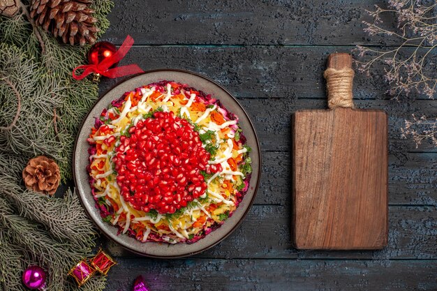 木の枝と木のまな板の横にザクロと食欲をそそるクリスマス料理の上面図食欲をそそる料理