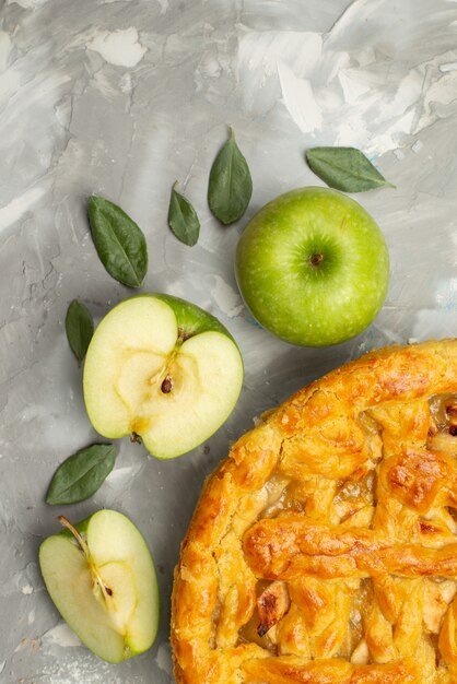 A top view apple cake round formed delicious with fresh apples flour on the white desk cake dough