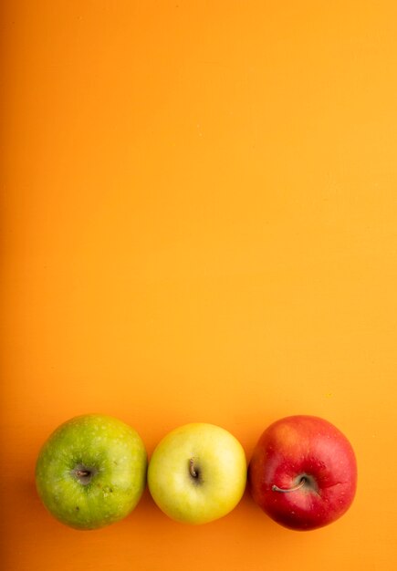 오렌지 배경에 복사 공간 하단에 상위 뷰 사과 믹스 빨간색 노란색과 녹색 사과