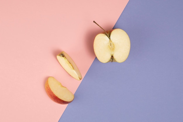 Top view of apple on pink and purple background