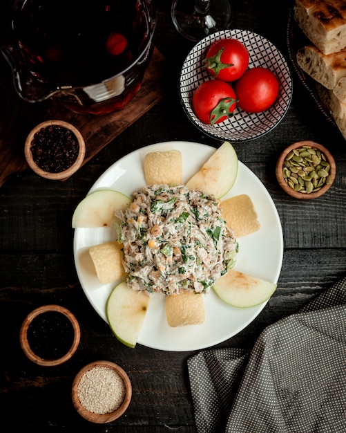 Вид сверху тарелка яблочного салата с кукурузным салатом, курицей, майонезом и изюмом