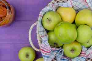 Free photo top view of apples in basket with apple jam  on purple background