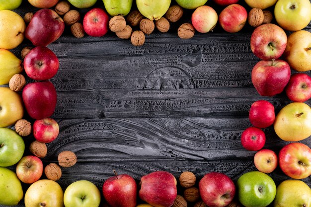 トップビューリンゴと梨とナッツとクルミグレー木製水平コピースペース