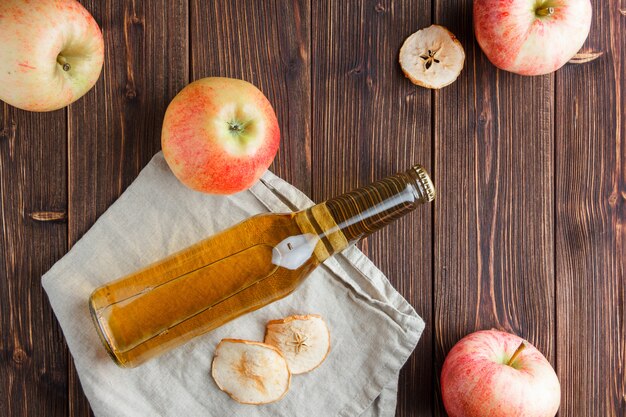 Top view apples with apple juice on cloth and wooden background. horizontal