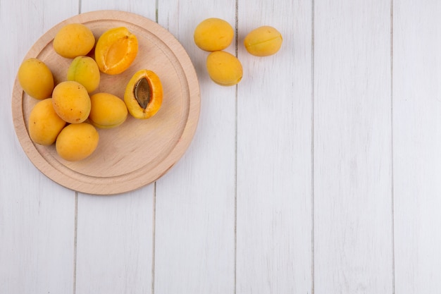 Top view of apricots on a stand on a white surface