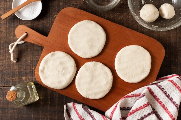 Top view arepas dough on wooden board