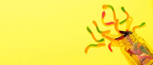 Top view arrangement of candies on yellow background with copy space