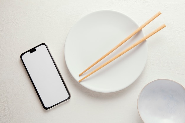 スマートフォンとエレガントな食器の上面図の配置