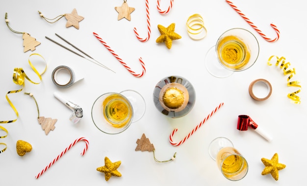 Free photo top view arrangement of glasses of champagne and candies for new year party