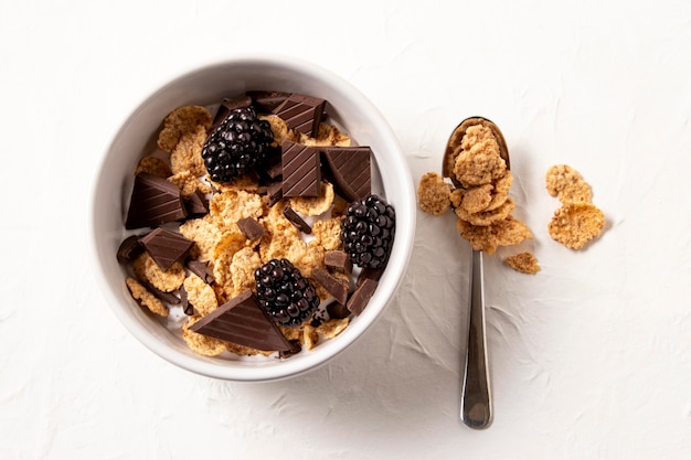 Top view arrangement of healthy bowl cereals with chocolate