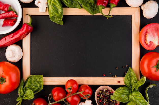 Top view arrangement of vegetables with empty blackboard