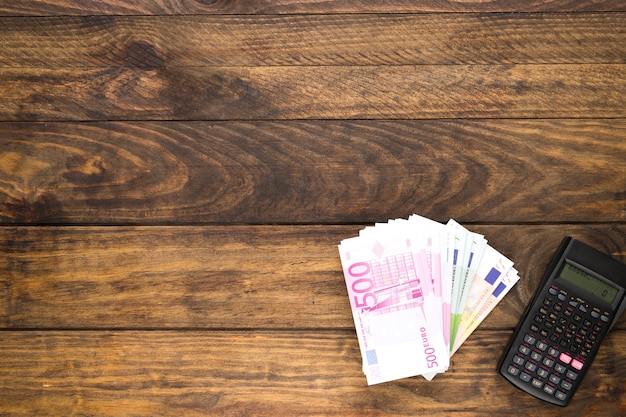 top view arrangement with banknotes and pocket calculator
