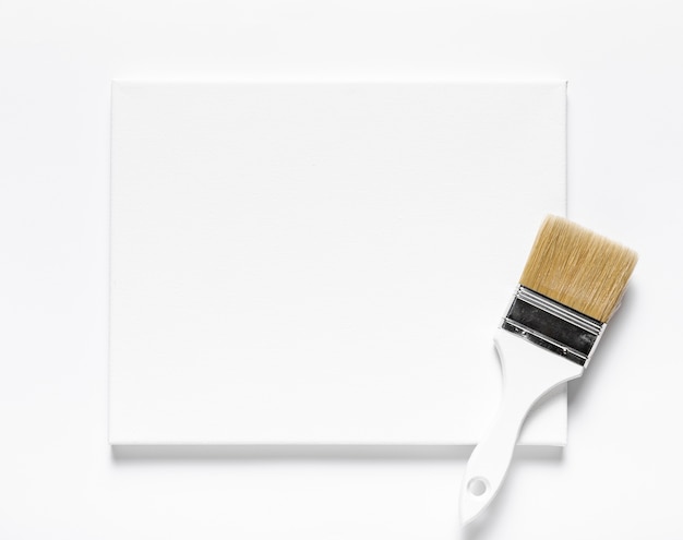 Free photo top view arrangement with canvas and brush on white background