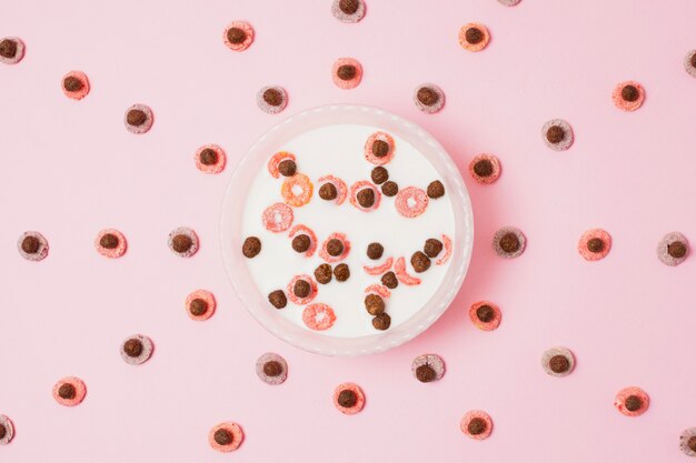 Top view arrangement with cereal bowl on pink background