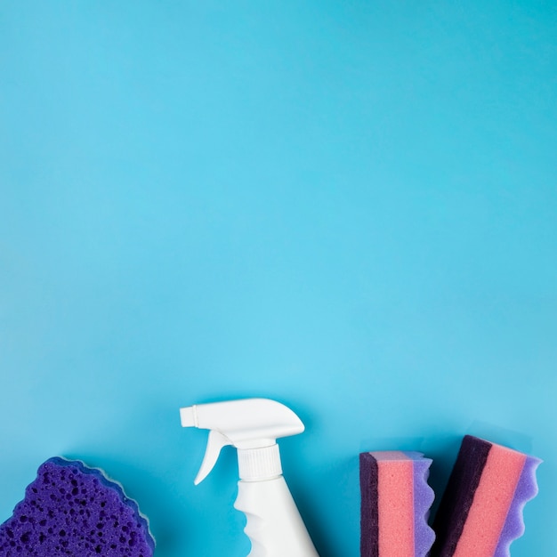 Top view arrangement with cleaning products on blue background