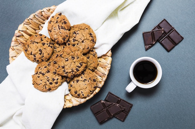 Top view arrangement with cookies, dark chocolate and coffee