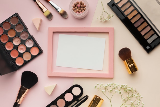 Top view arrangement with cosmetics and pink frame