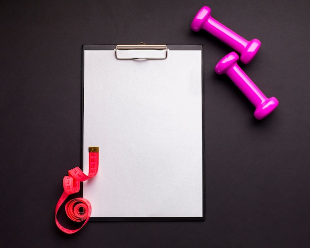 Top view arrangement with dumbbells and clipboard