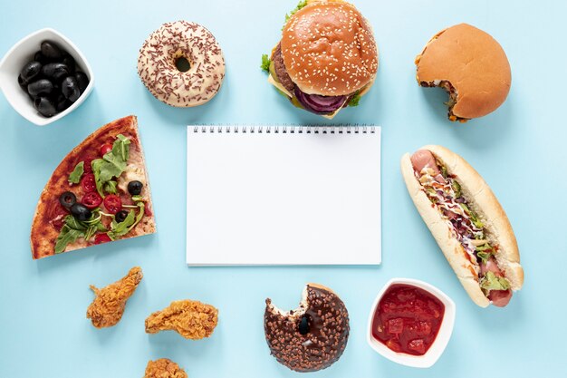 Top view arrangement with fast food and notebook